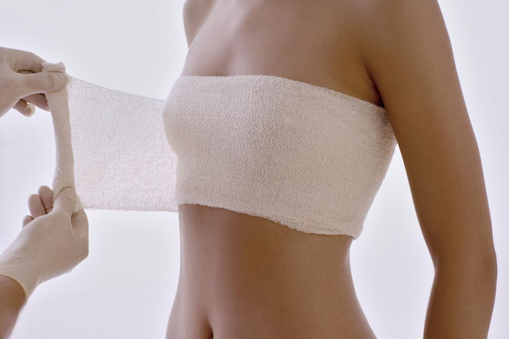 Bandage som viras runt kvinnas bröst